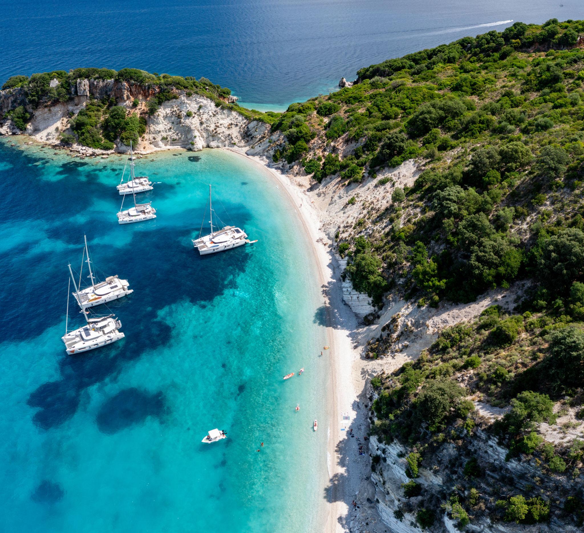 Gidaki beach, Ithaca — turquoise cove accessible only by boat, with sailboats anchored offshore